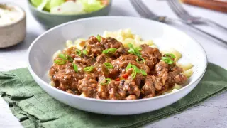 Pyszny strogonow z wieprzowiny z pieczarkami i ogórkiem kiszonym, podany z makaronem. Idealny przepis na obiad.