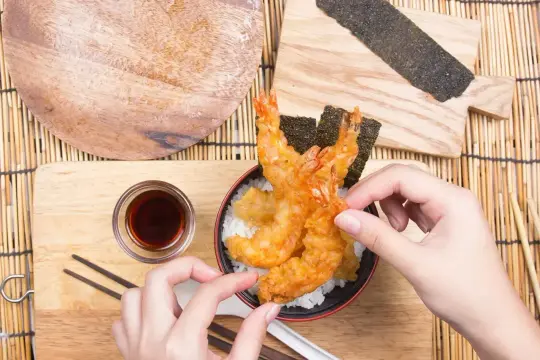 Chrupiące krewetki w cieście tempura na ryżu, gotowe do jedzenia. Prosty tempura przepis na pyszny obiad.