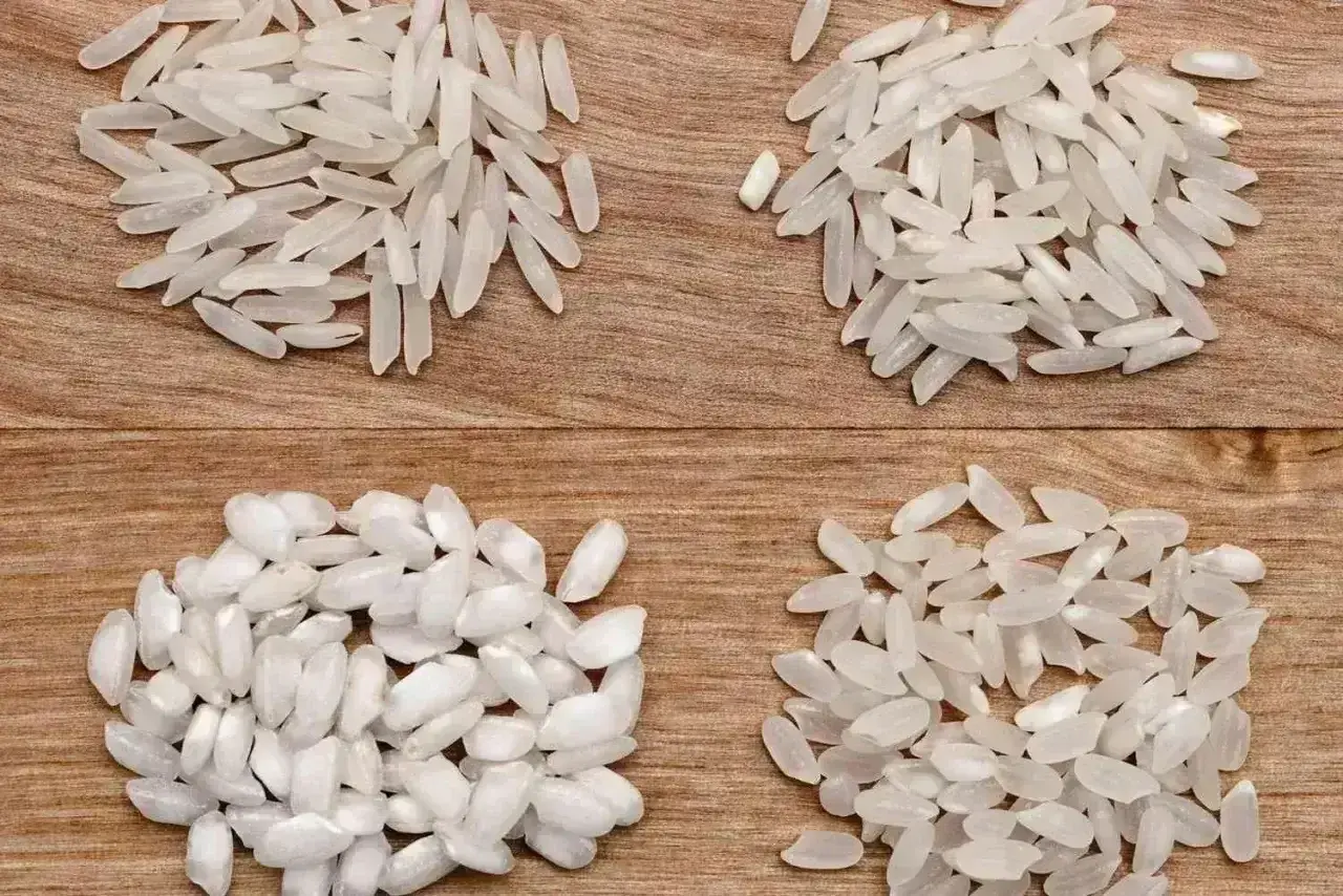 Cztery kupki ryżu na drewnianym tle. Dwie górne to długie ziarna, idealne do risotto. Dwie dolne to krótsze, bardziej okrągłe ziarna.